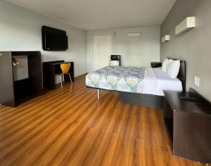 Schlafzimmer mit einem Bett und Holzboden in der Unterkunft Motel 6-Delano, CA in Delano