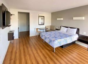 ein Hotelzimmer mit einem Bett und einem Tisch in der Unterkunft Motel 6-Delano, CA in Delano