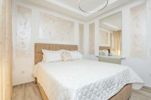 a white bedroom with a large white bed in it at Oasis Central Stay in Bar