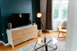 a living room with a flat screen tv on a dresser at Home from Home in Tyne and Wear in Westoe