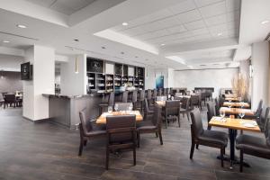 a dining room with wooden tables and chairs at Hilton Vancouver Metrotown in Burnaby