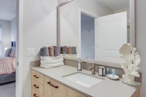 a bathroom with a sink and a large mirror at Modern getaway minutes from Truist park! in Atlanta
