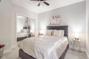 1 dormitorio con 1 cama grande y espejo en Modern getaway minutes from Truist park! en Atlanta