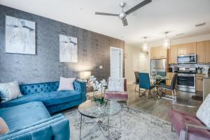 sala de estar con sofá azul y mesa en Modern getaway minutes from Truist park! en Atlanta