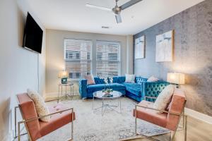 a living room with a blue couch and chairs at Modern getaway minutes from Truist park! in Atlanta