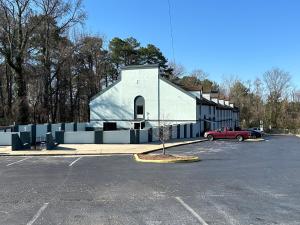 eine Kirche mit einem roten Auto auf einem Parkplatz in der Unterkunft HomeTowne Studios by Red Roof Richmond, VA - W Broad St in Richmond