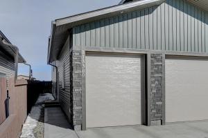 een garage met twee deuren aan de zijkant van een gebouw bij Brand New Modern Escape in Grande Prairie