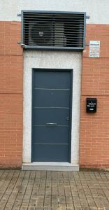 una puerta de garaje azul en un edificio con ventana en Estudio Palacio Congresos, en Sevilla