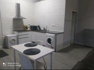 a kitchen with a washing machine and a table in it at Estudio Palacio Congresos Aeropuerto in Seville +10 photos