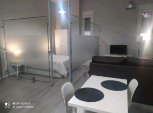 Habitación con cama, mesa y sofá en Estudio Palacio Congresos en Sevilla