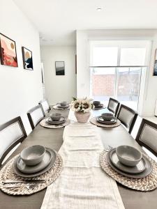 un comedor con una mesa con platos y sillas en NEW Luxurious 5BR/3BATHES Home, Spacious and Retreat location with Modern Amenities en Ontario