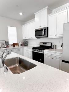a kitchen with white cabinets and a stainless steel sink at NEW Luxurious 5BR/3BATHES Home, Spacious and Retreat location with Modern Amenities in Ontario