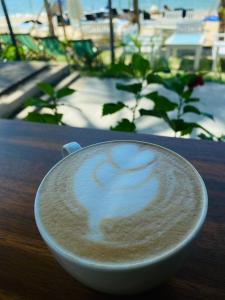 a cup of coffee sitting on top of a table at Sealight Villa and House Phu Quoc in Phú Quốc