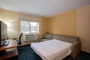 a hotel room with a bed and a desk and a window at Fairfield Inn & Suites by Marriott New York Queens/Fresh Meadows in Queens