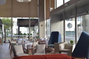 un restaurante con mesas y sillas y un reloj en la pared en Doubletree By Hilton Trujillo, en Trujillo