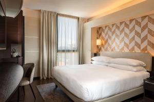 a hotel room with a bed and a window at Doubletree by Hilton Milan Malpensa Solbiate Olona in Solbiate Olona