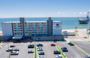 a hotel with a parking lot in front of the ocean at DoubleTree by Hilton Corpus Christi Beachfront in Corpus Christi