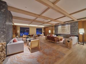 a living room with couches and chairs and tables at DoubleTree by Hilton Changbaishan Hot Spring in Antu