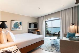 a hotel room with a bed and a couch at DoubleTree by Hilton Malta in St Paul's Bay