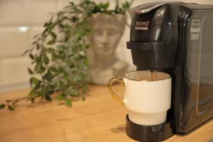 uma cafeteira está a fazer uma chávena de café em THEMIS URBAN STAY em Komotini