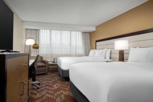 een hotelkamer met 2 bedden en een bureau bij Doubletree By Hilton Greensboro Airport in Greensboro