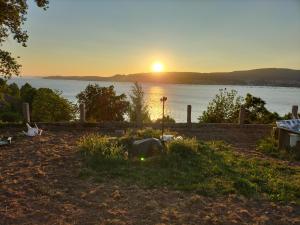 a sunset over the water with a tent in the grass at Apartamento Portocelo, en Marín (Pontevedra) in Marín +7 photos