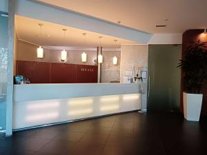 a lobby with a reception counter with lights at Best Western Plus The Hub Hotel in Milan
