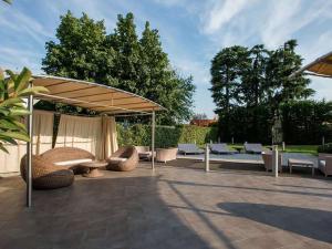 a patio with chairs and an umbrella and tables and chairs at Best Western Plus The Hub Hotel in Milan