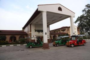Panari Resort, BW Signature Collection في Nyahururu: ثلاث عربات قولف تقف تحت محطة بنزين
