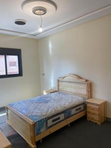 ein Schlafzimmer mit einem Holzbett und einem Nachttisch in der Unterkunft Azrou in Azrou