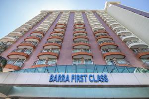 a large pink building with a barbara first class sign at Flat Barra First in Rio de Janeiro