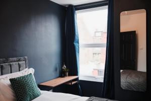 a bedroom with a window and a bed and a table at Lamara Flat 2, Liverpool in Liverpool