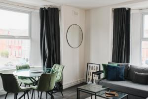 uma sala de estar com uma mesa e um sofá em Lamara Flat 2, Liverpool em Liverpool