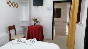 a room with two beds and a table with a vase of flowers at HOTEL VIEILLE MAISON in Quito