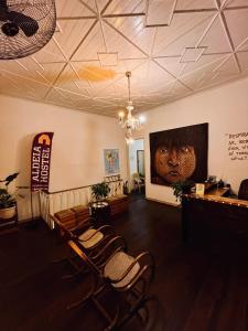 une salle d'attente avec des chaises et un tableau sur le mur dans l'établissement Aldeia Hostel, à Manaus