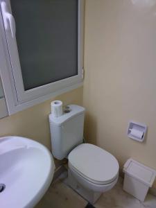 a bathroom with a white toilet and a sink at Kolonaki Private Room in Athens