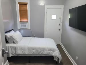 a white bedroom with a bed and a flat screen tv at Chilltown in Wakefield