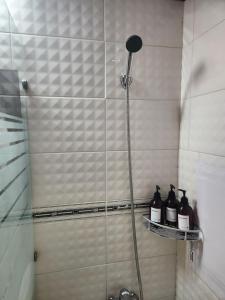 una doccia con bottiglie su una mensola in bagno di Stay Mido a Busan