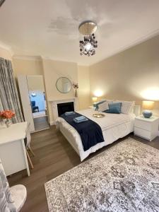 a bedroom with a large bed and a chandelier at Greenwich Holiday Home in London