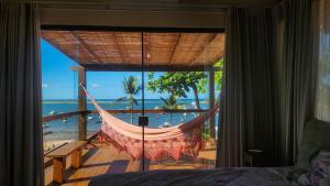 a hammock in a room with a view of the ocean at Casa Aberta in Itacaré
