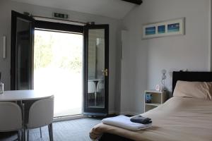 um quarto com uma cama, uma mesa e uma janela em The Stables Lodge Stansted em Takeley