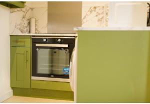 a kitchen with a stove and a green refrigerator at Lamara Flat 3, Liverpool in Liverpool