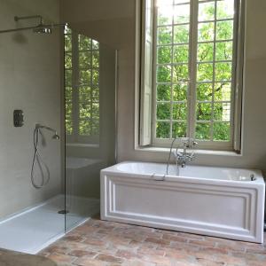 a white bath tub in a bathroom with a window at Le Pavillon de l'Orangerie in Meursanges