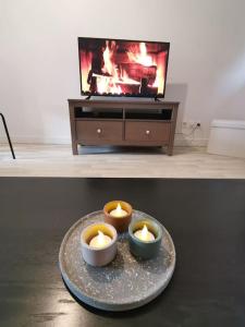 two candles on a plate in front of a tv at Appartement Spacieux 80 m2 in Bobigny