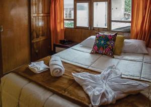 a large bed with towels on it in a bedroom at BEAUTIFUL, SPACIOUS & COZY HOUSE LOCATED IN THE HEART OF CUSCO in Cusco