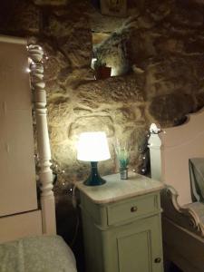 une lampe assise sur une commode dans une chambre dans l'établissement Quinta da Maínha - Charming Houses, à Braga