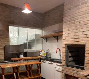 a kitchen with a brick wall and a brick oven at Casa charme aluguel de temporada in Sarandi