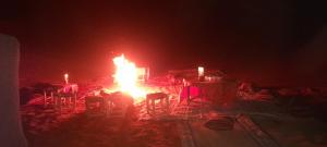 um quarto com uma mesa iluminada e cadeiras à noite em Erg Chebbi Starlight Camp em Merzouga