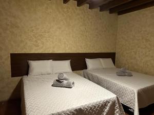 Dos camas en una habitación con toallas. en Casa Los Héroes en Antigua Guatemala