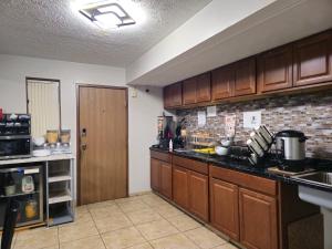 a kitchen with wooden cabinets and a counter top at Budgetel inn & Suites in Fort Scott